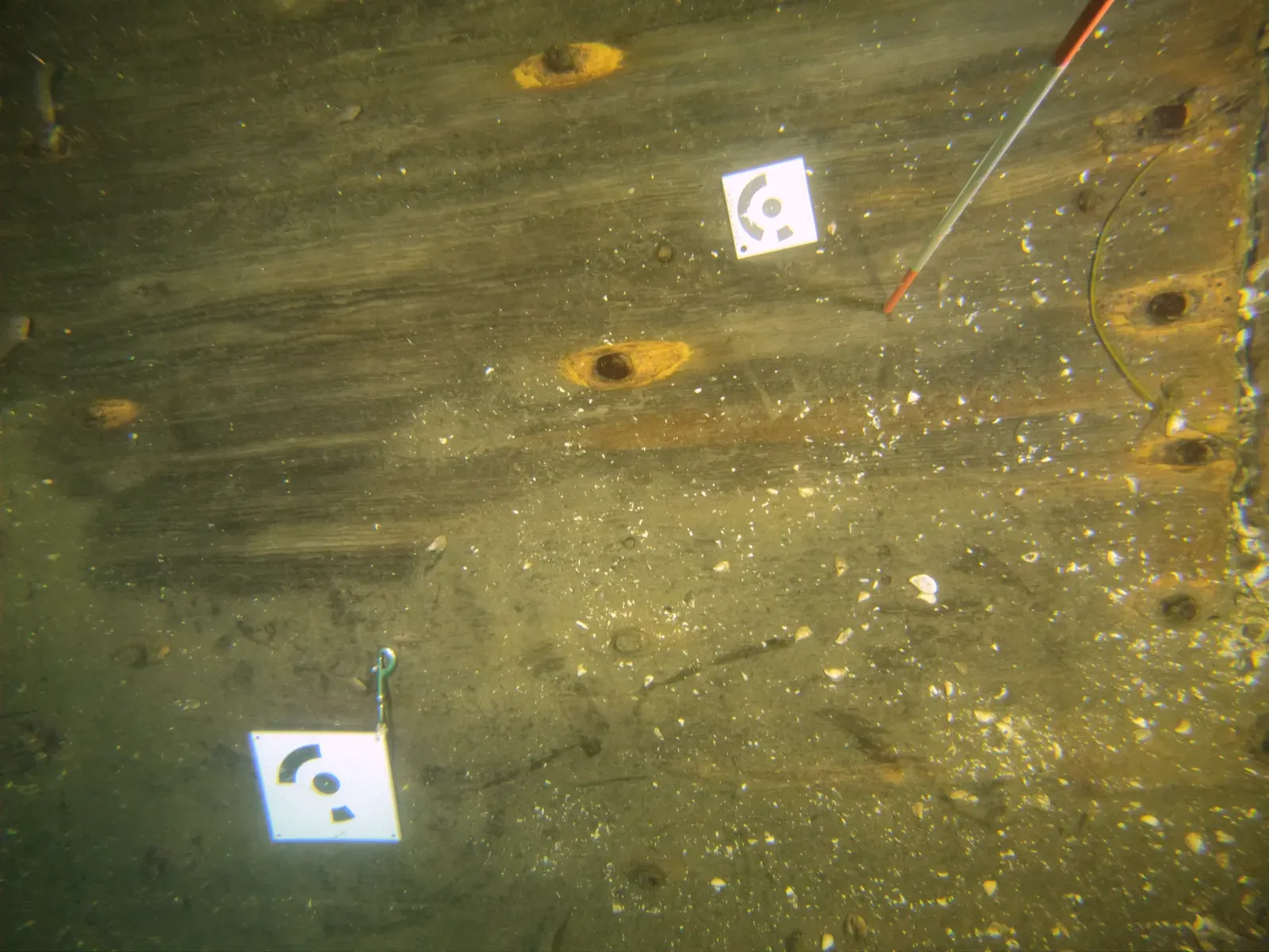 Deux cibles codées posées au plancher de bois de la zone 5, une de 7,5 cm et une de 15 cm